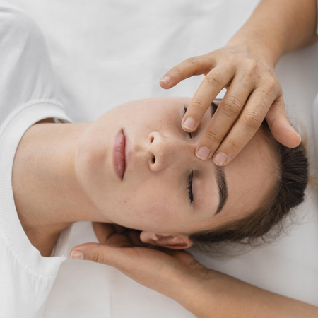 osteopathist-treating-patient-by-massaging-her-face